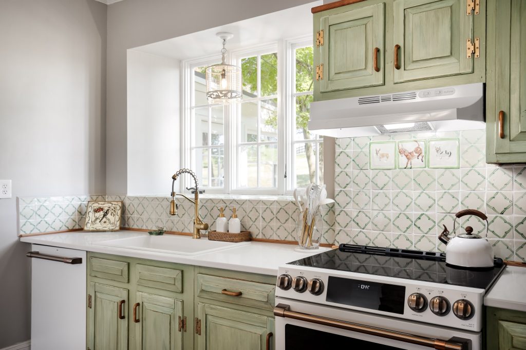 The kitchen at Still Meadow Farm Virginia with green wooden cabinets and a white and gold patterned backsplash